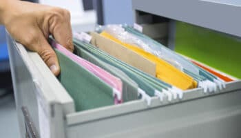 Hand of Man Search files document in a file cabinet in work offi