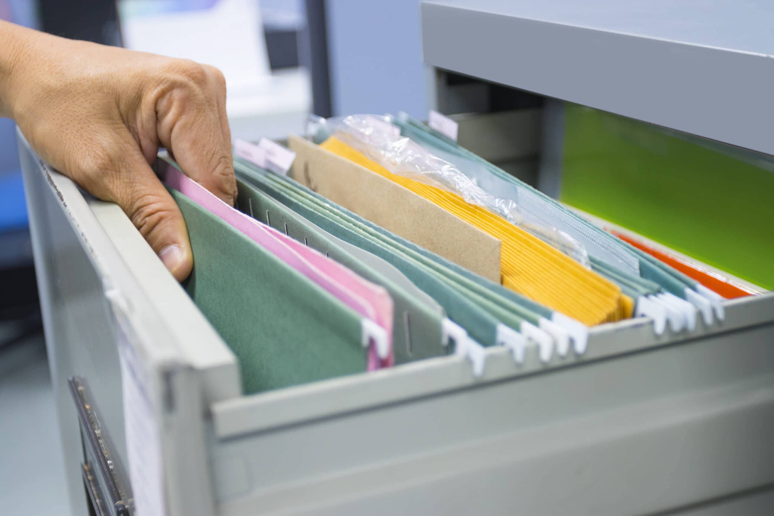 Hand of Man Search files document in a file cabinet in work offi